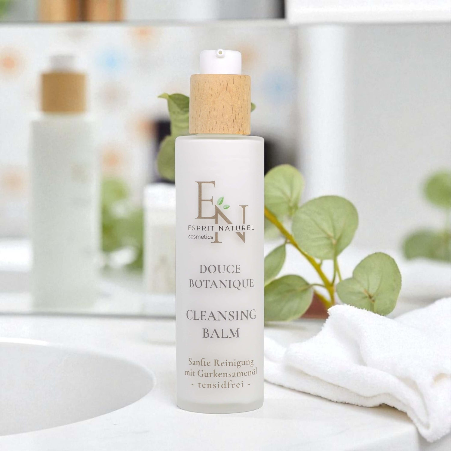 Esprit Naturel Cleansing Balm in Badezimmer-Setting mit Spiegel und weißen Handtüchern – stilvolle Naturkosmetik mit elegantem Design