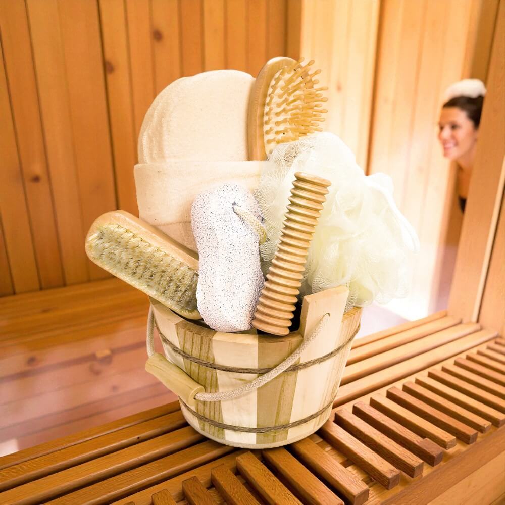 Frau in Sauna mit 7-teiligem Wellness-Set im Holzbottich – wohltuende Pflege mit Naturmaterialien.