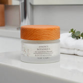 Esprit Naturel – palmölfreie Rejuvenating Day Care in einem edlen Glastiegel mit Holzdeckel, präsentiert auf einer weißen Keramikfläche vor natürlichem Badezimmer-Hintergrund